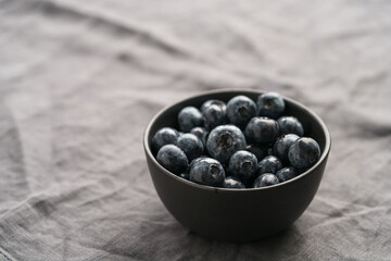 Freshly washed organic blueberries in a black bowl closeup