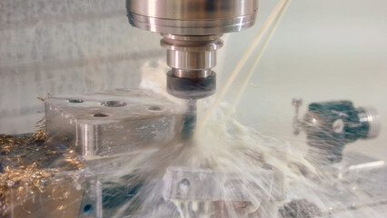Close-up drilling machine with water splashes and many metallic shavings. Close-up cnc machining...
