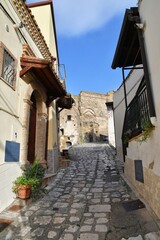 A narrow street between the old houses of Grottole, a village in the Basilicata region, Italy.