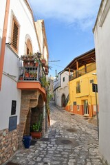 Fototapeta na wymiar A narrow street between the old houses of Grottole, a village in the Basilicata region, Italy. 