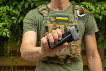 A military man holds a medical tourniquet in his hands to stop blood in first aid and prevent bleeding. Combat tactical equipment. Combat use Turnstile.