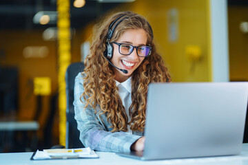 Female customer service representative in a headset is consulting clients online. Call center and...