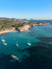 Cala Comte beach in Ibiza. The island of Es Vedra can be seen in the background. - obrazy, fototapety, plakaty
