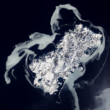 Sea ice swirling around Shikotan Island at the southern end of the Kuril chain, Top view of a volcanic island. Aerial view of winter sea ice texture. Elements of this image furnished by NASA.