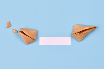 Open fortune cookie with note without text on blue background