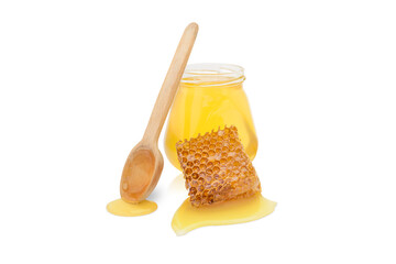 isolated jar with honey next to a wooden spoon and a piece of beeswax with honey