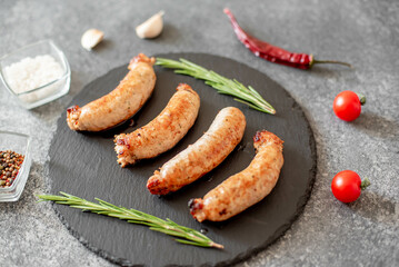 grilled sausages from turkey meat with spices on a stone background 