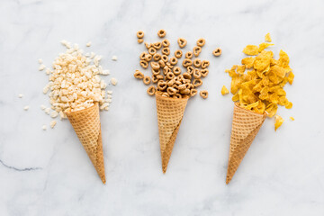 Waffle cones filled with various types of cereal.