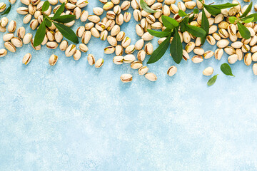 Pistachios. Pistachio nuts with green leaves. Healthy natural vegetarian organic food. Top view, copy space