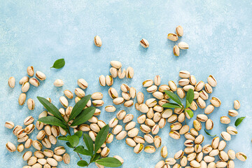 Pistachios. Pistachio nuts with green leaves. Healthy natural vegetarian organic food. Top view, copy space
