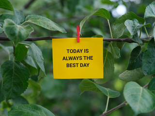 A paper note with the phrase Today is Always the Best Day on it attached to a tree with a clothes...