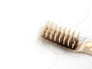 White comb with hair loss, hair fall on white background and copy space.