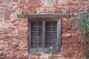 An old wooden framed window with leaded window panes in a house in Dunster in Somerset, England