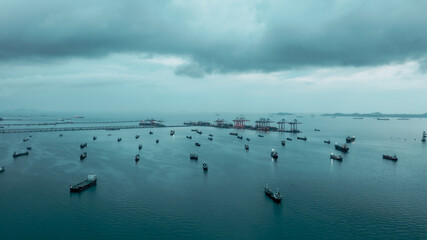 Obraz na płótnie Canvas Aerial view Oil ship tanker parking in sea and cloud storm background, waiting for load and unload oil from refinery for transportation.