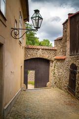 Fototapeta na wymiar historical circular path along the city wall of Telc in czechia with wooden gate and small passage door. The center of Telc in southern Moravia, Czech Republic, is a UNESCO World Heritage Site
