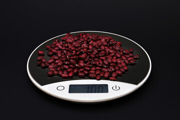 Bean seeds weighing 100 grams on electronic scales. Close-up