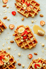 Top view traditional Belgian waffle with fresh fruit, maple syrup and nuts. Flat lay. Summer breakfast, cooking concept