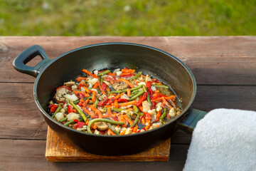 Bright colored vegetables in a frying pan with a napkin stewed in spices. horizontal photo