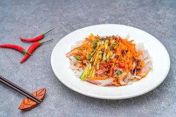 A plate of shaanxi qishan spicy red oil cold skin on a wooden table