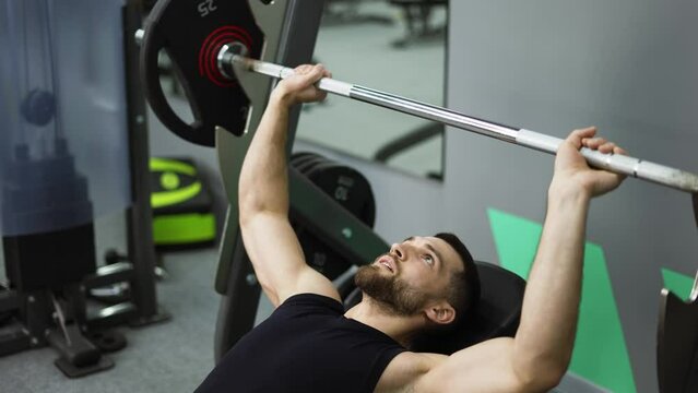 Men laying and working out barbell bench press in the gym