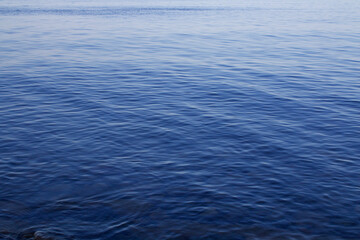 Naklejka premium Blue sky and sea. The flat surface of a calm sea at dawn.