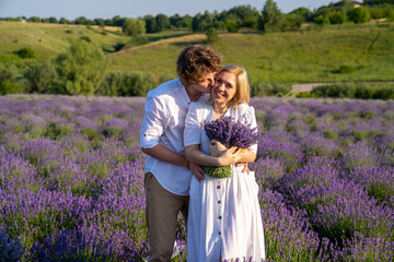 couple in white outfit in lavender field, photo session. man is proposing to woman with ring....