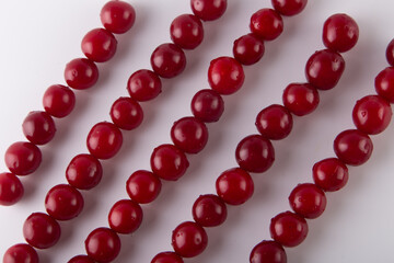 Red fresh cherries lay in lines on white background. Top view, flat lay