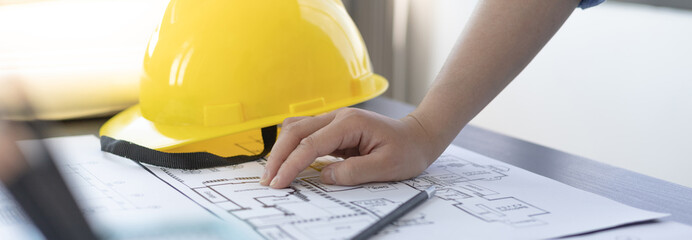 Architectural building design and construction plans with blueprints, Young man was designing a...