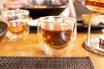 a girl eats japanese food with chopsticks in a restaurant. teapot with tea on the table
