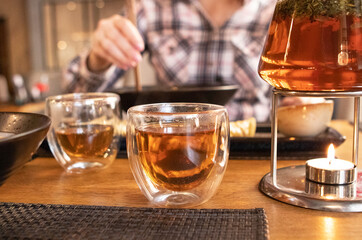 a girl eats japanese food with chopsticks in a restaurant. teapot with tea on the table