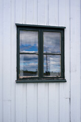 green window in a white wooden wall