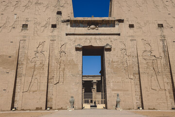 View to the main entrance of an Ancient Egyptian Edfu Temple showing the first pylon in the Sunny...