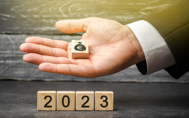 Businessman holding wood blocks with euro money and 2023. Budget planning concept. Financial goals...
