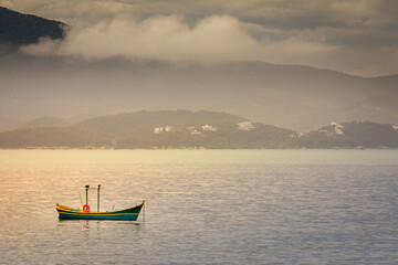 Naklejka premium Bay with fishermen boat in Jurere beach at sunset Florianopolis, Brazil