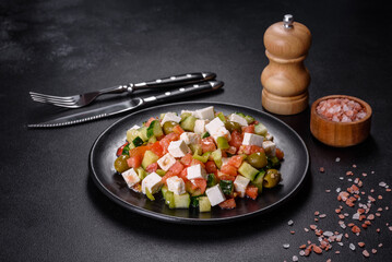 Greek salad with juicy tomatoes, feta cheese, lettuce, green olives, cucumber, red onion and fresh parsley