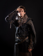 A guy in a steampunk or post-apocalyptic image, looks into the distance, portrait on a black background