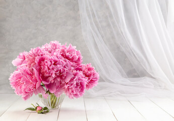 Bouquet of pink peonies in a vase on a wooden table. Gift Valentine's Day