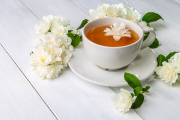 Obraz na płótnie Canvas Jasmine tea in a cup on a wooden background. Copy space