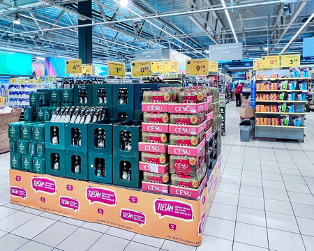LATVIA, RIGA, JULY, 2022: Pallets in the sales area with beer from Latvian producers in the RIMI hypermarket in Riga, Latvia. Retail industry. Grocery shopping. Food quality.