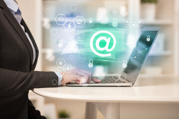 Hands working on laptop with digital icons concept