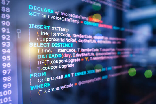 SQL (Structured Query Language) code on computer monitor and server room background. Example of SQL code to query data from a database.