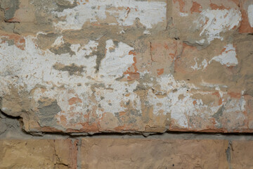 Old wall closeup. Grunge plaster and brick wall textured background. Selective focus