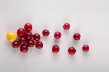 Variety of fresh red and yellow cherries on white background. Top view, flat lay, copy space for text