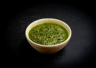 Basil pesto on a dark surface