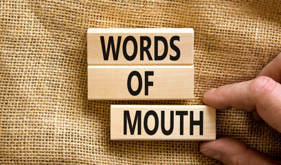 Words of mouth symbol. Concept words Words of mouth on wooden blocks on a beautiful canvas table...