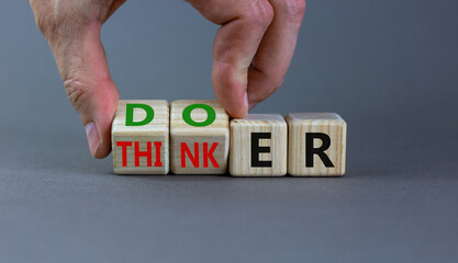 Doer or thinker symbol. Concept words Doer or thinker on wooden cubes. Businessman hand. Beautiful grey table grey background. Business and doer or thinker concept. Copy space.