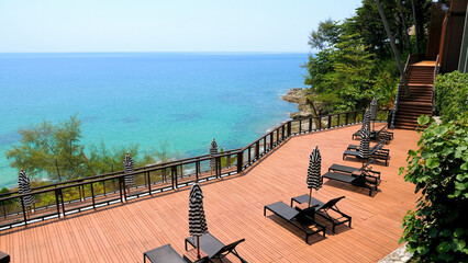 Obraz premium Summer vacation in modern resort. Empty sun lounges with umbrellas in luxury hotel with view on turquoise sea. Concept of holidays in Thailand, Phuket, Asia.