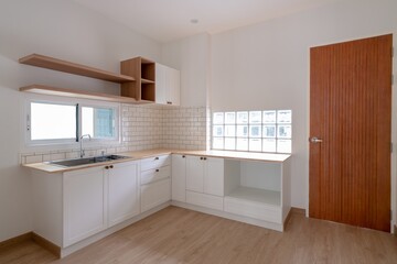 Kitchen in a house in white minimal style top counter with pine wood and teak wood door