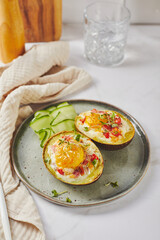 Avocado baked with egg, ham, tomatoes and cheese. Keto lunch recipe. After baking