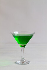 green cocktail.Apple martini cocktail on the white background. Homemade Green Alcoholic drinks in martini glasses with apple slice. copy space. vertical